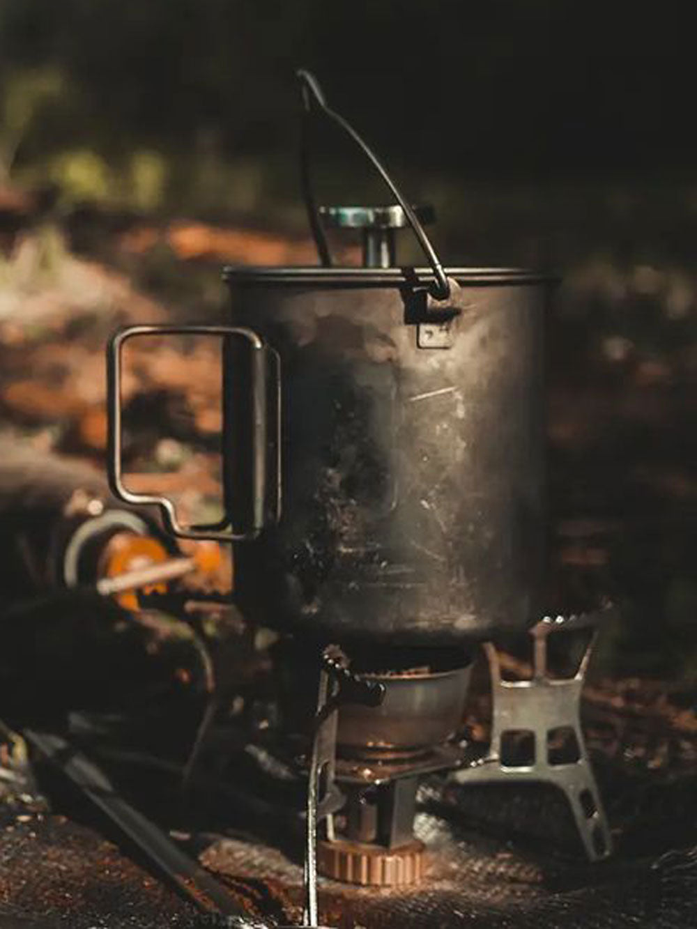 A man sitting in the woods making coffee with bestargot